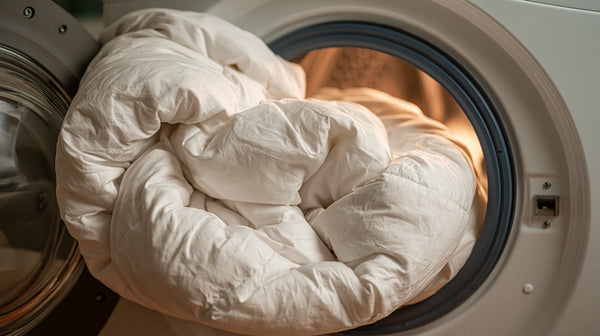 Oversized white comforter overflowing from a domestic washing machine drum