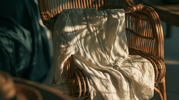 Rumpled natural linen shirt draped over a rattan chair in strong Florida sunlight
